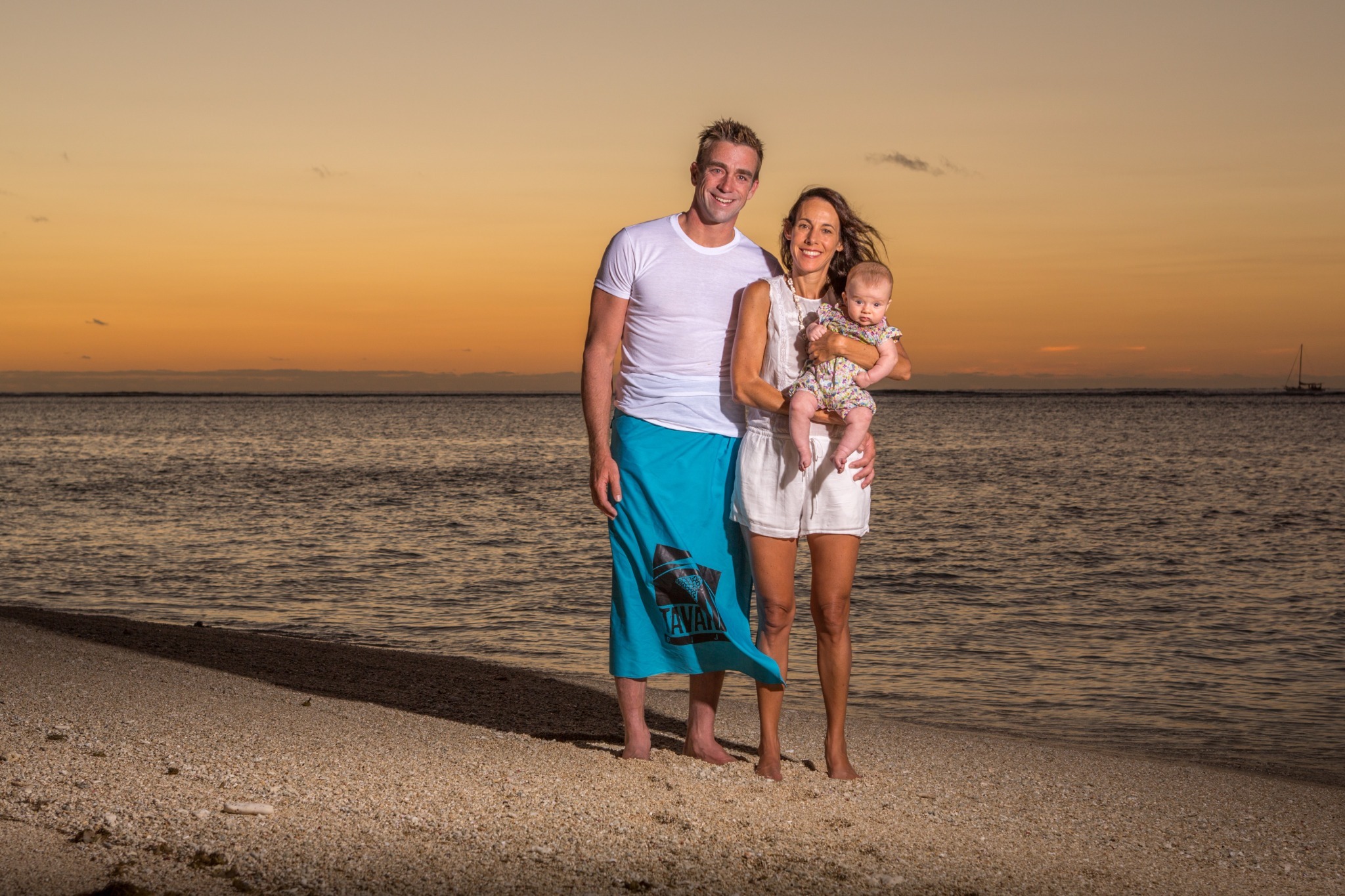 Andrew, Sara, and three-month-old Elliot together on the beach at Tavarua in Fiji at sunset